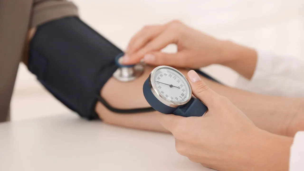 Clinician measuring a patient's blood pressure during an annual physical